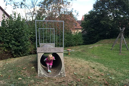 Mädchen kommt aus einem Tunnel zum durchkriechen heraus.